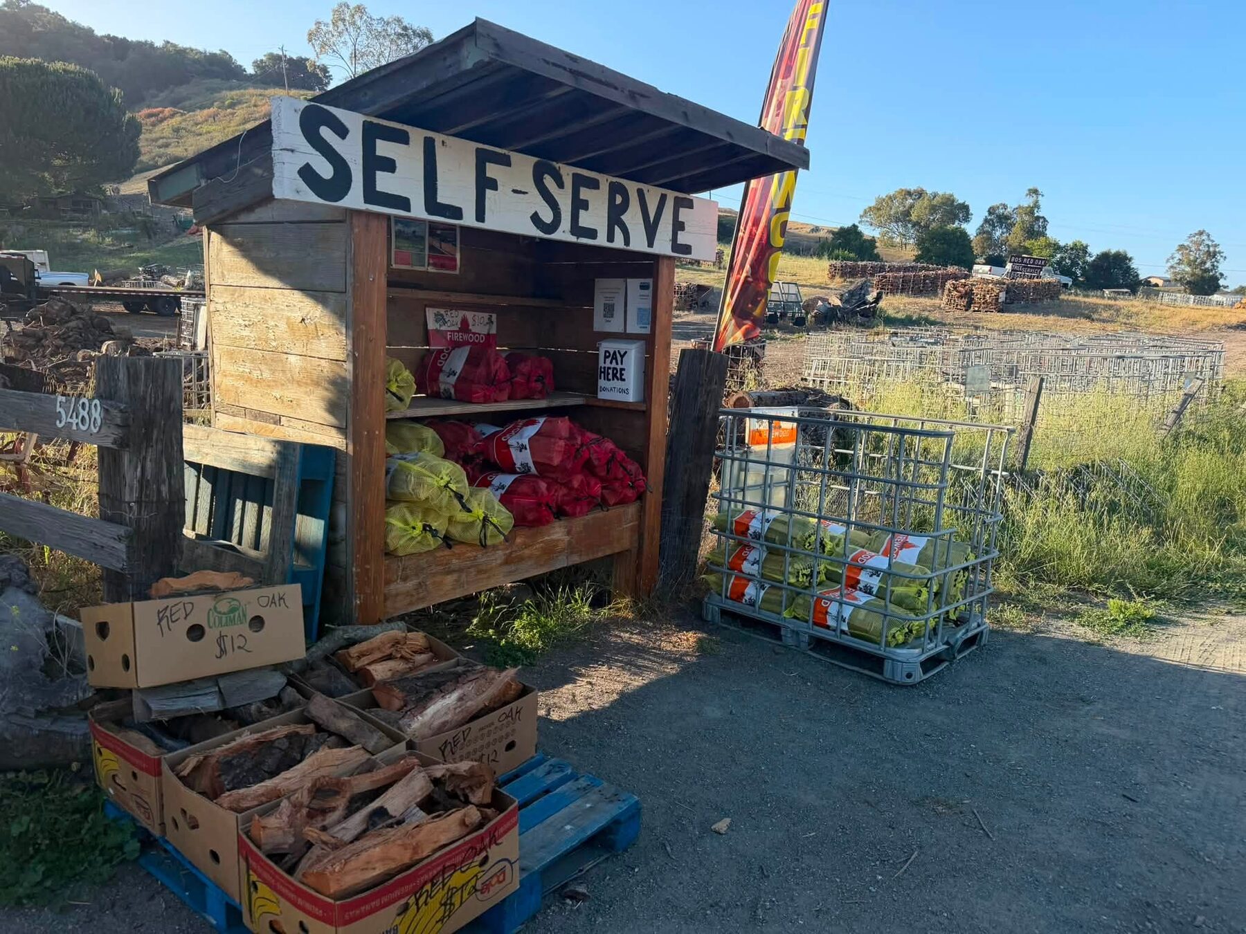 The 805 Red Oak self-serve firewood stand on Ontario Road, stocked with bagged wine-infused oak and boxes of red oak
